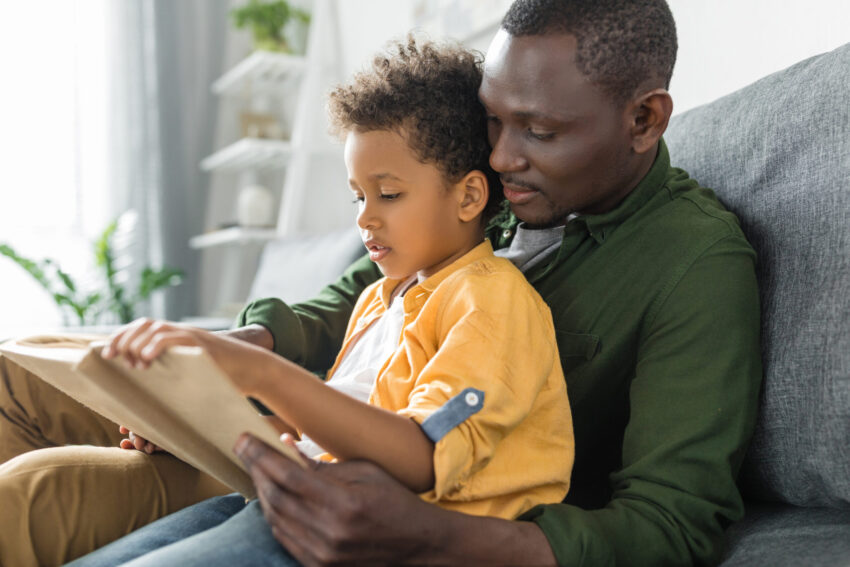 Dad reading book to son cuddled