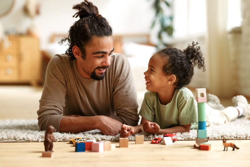 Dad playing with toys with daughter on the floor
